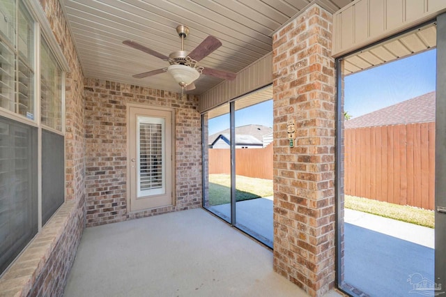 unfurnished sunroom featuring a ceiling fan and wooden ceiling