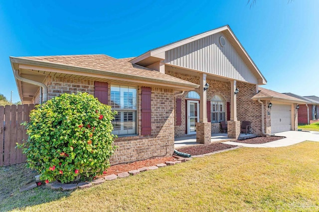 view of front of house with brick siding, an attached garage, a front lawn, and fence