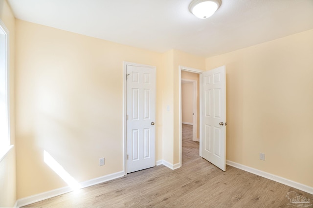 unfurnished bedroom with light wood-type flooring and a closet