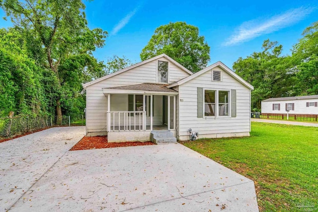 bungalow-style home with covered porch, concrete driveway, and a front yard