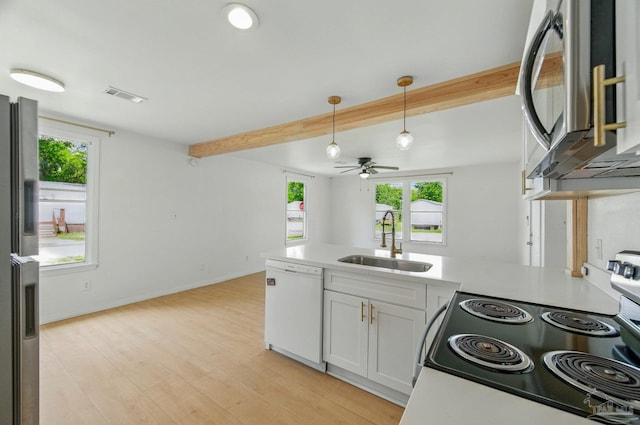 kitchen with visible vents, beam ceiling, a sink, a peninsula, and stainless steel appliances