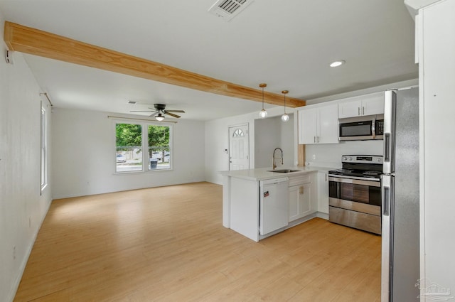 kitchen with a sink, stainless steel appliances, open floor plan, a peninsula, and visible vents