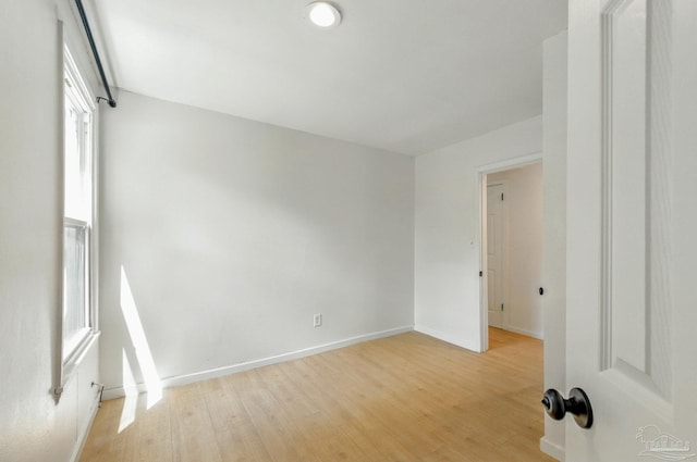 spare room featuring light wood-type flooring and baseboards
