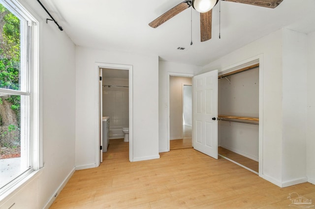 unfurnished bedroom featuring light wood-type flooring, baseboards, visible vents, and multiple windows