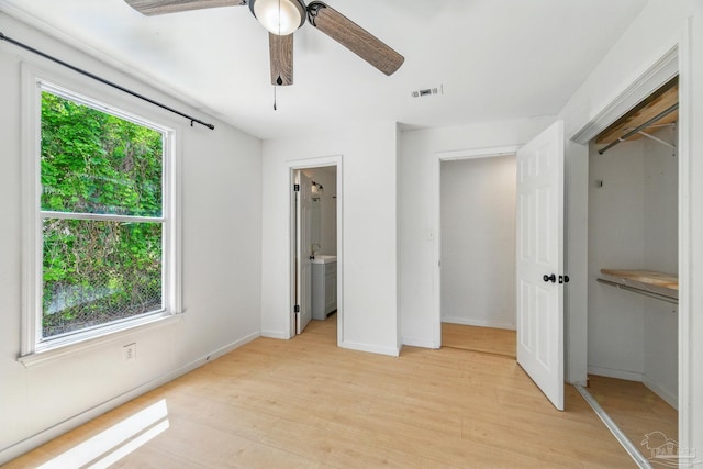 unfurnished bedroom featuring light wood-style flooring, a ceiling fan, baseboards, visible vents, and a closet