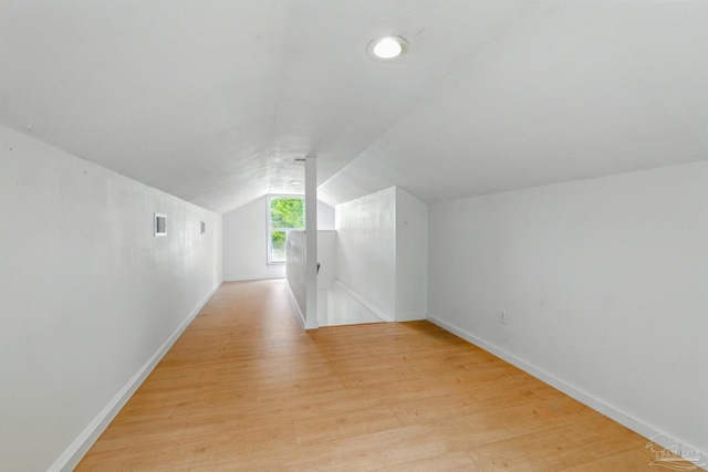 bonus room featuring baseboards, vaulted ceiling, and light wood finished floors