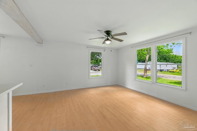 empty room with baseboards, beamed ceiling, a ceiling fan, and light wood finished floors