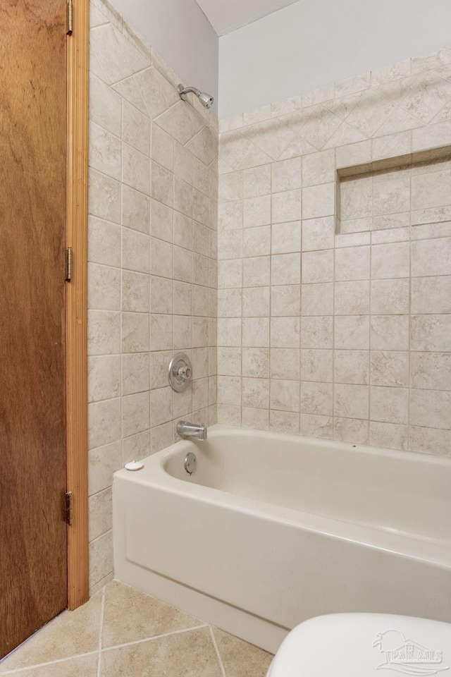 bathroom featuring tile patterned flooring and tiled shower / bath