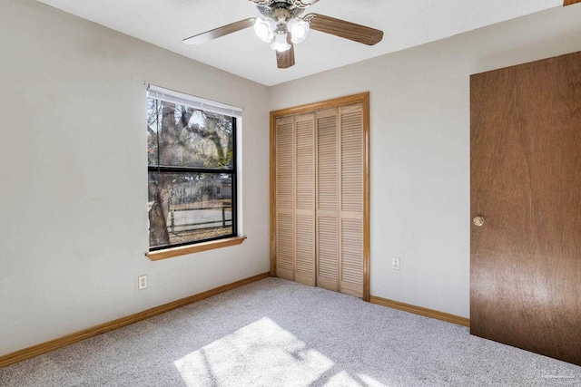 unfurnished bedroom with carpet, ceiling fan, and a closet