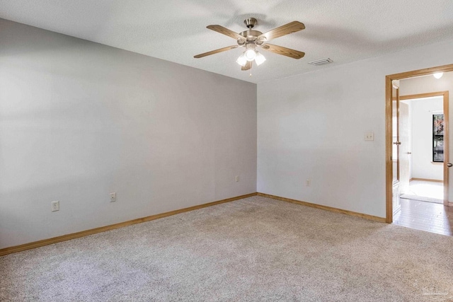 empty room with carpet flooring, a textured ceiling, and ceiling fan