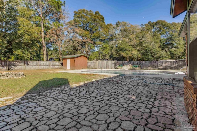 view of yard featuring a storage unit and a fenced in pool