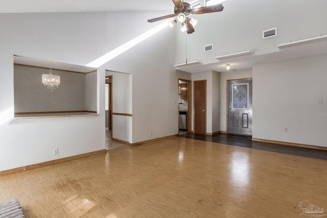 empty room with ceiling fan with notable chandelier and high vaulted ceiling