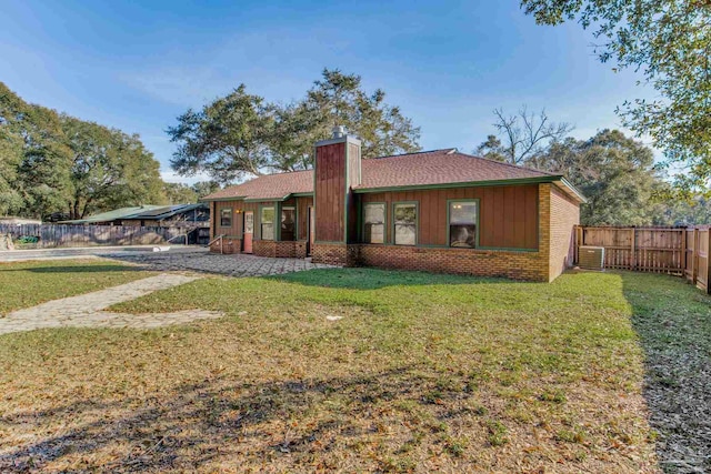 view of front of home with a front yard and cooling unit