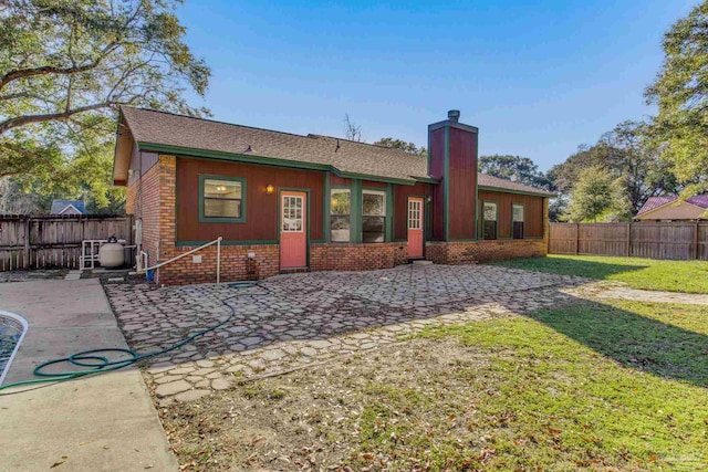 back of property featuring a lawn and a patio area