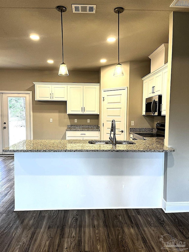 kitchen featuring a sink, stainless steel appliances, visible vents, and dark stone countertops