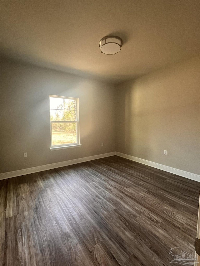 unfurnished room featuring dark wood-style floors and baseboards