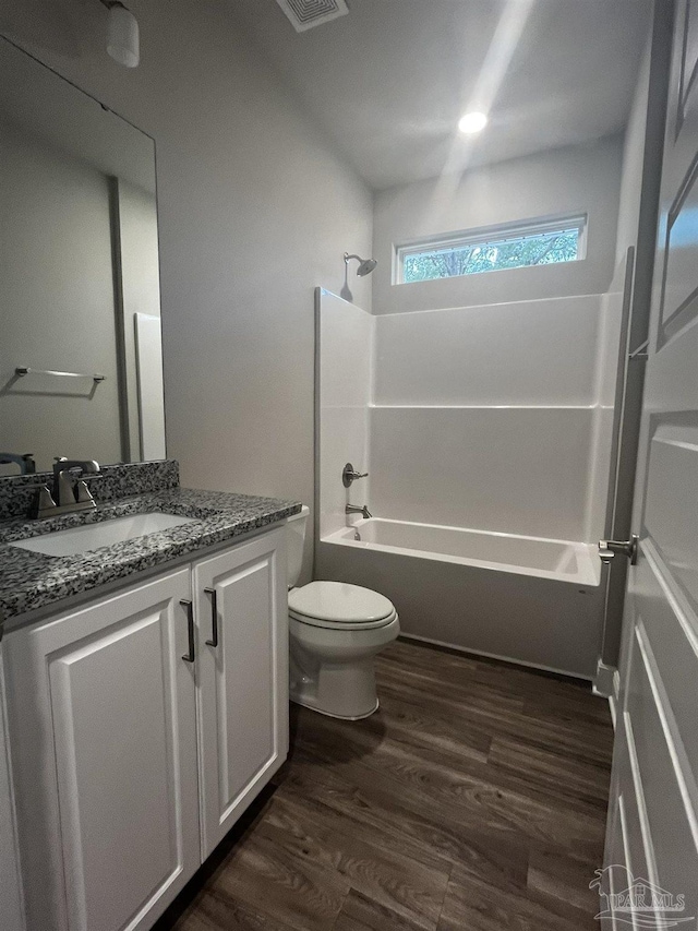 full bath with bathtub / shower combination, vanity, toilet, and wood finished floors