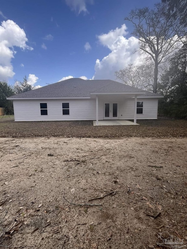 rear view of property with a patio area and a shingled roof