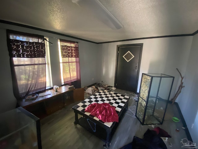 bedroom with a textured ceiling, hardwood / wood-style flooring, and crown molding