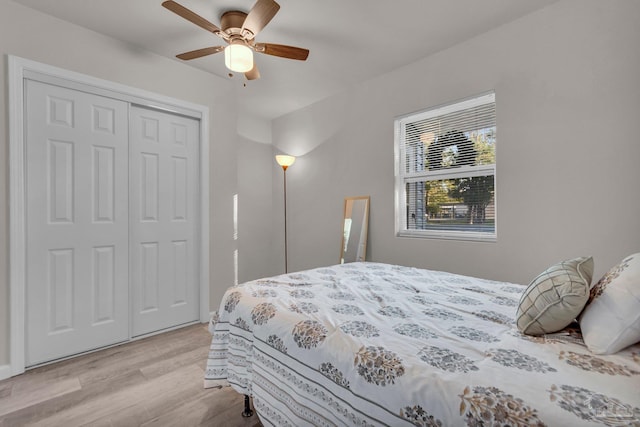 bedroom featuring ceiling fan, light wood-type flooring, and a closet