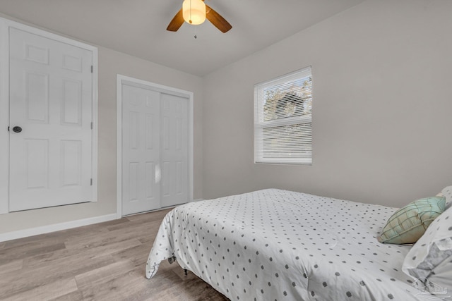 bedroom with ceiling fan, light hardwood / wood-style floors, and a closet