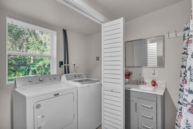 clothes washing area with washing machine and dryer and sink