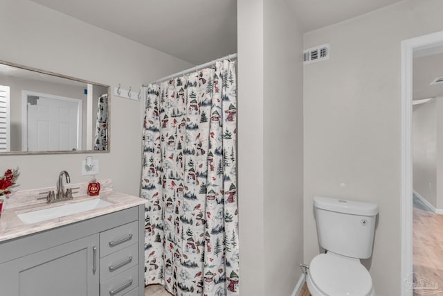 bathroom with a shower with shower curtain, hardwood / wood-style floors, vanity, and toilet