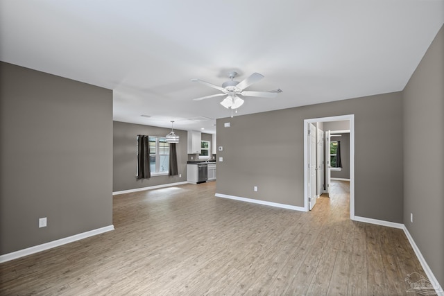 6609 Cedar St, Milton, FL 32570 - unfurnished living room featuring a ceiling fan and light wood-style floors