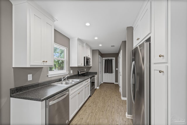 6609 Cedar St, Milton, FL 32570 - kitchen featuring stainless steel appliances, dark countertops, white cabinets, light wood-type flooring, and recessed lighting