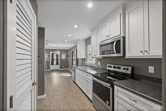 6609 Cedar St, Milton, FL 32570 - kitchen with stainless steel appliances, recessed lighting, white cabinets, and light wood-style floors