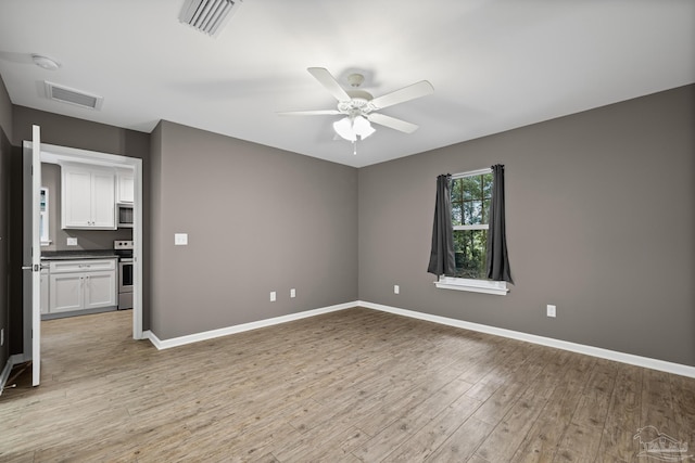 6609 Cedar St, Milton, FL 32570 - empty room with a ceiling fan, light wood-style floors, and a smoke detector