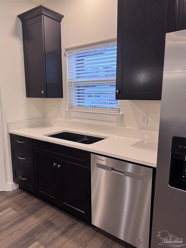 kitchen with dark hardwood / wood-style flooring, sink, and stainless steel appliances