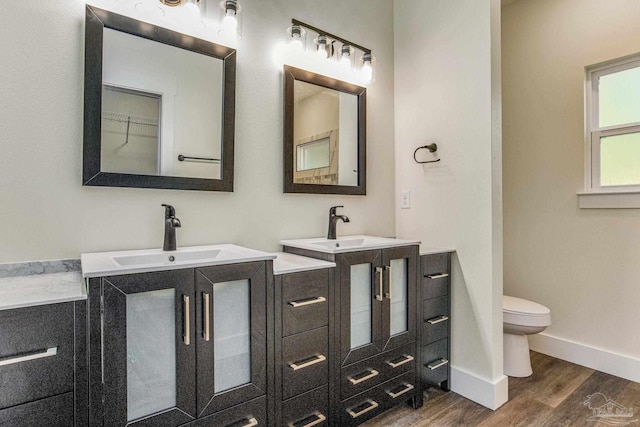 bathroom featuring wood-type flooring, vanity, and toilet