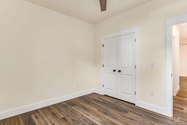 unfurnished bedroom with ceiling fan, dark hardwood / wood-style floors, and a closet