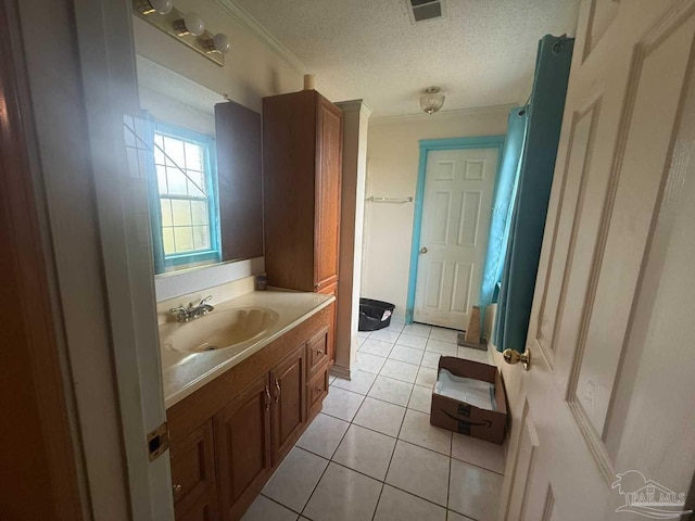 bathroom featuring tile patterned flooring, vanity, crown molding, and a textured ceiling