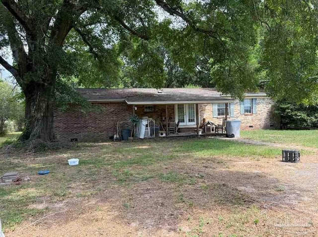 back of house featuring french doors, brick siding, and crawl space