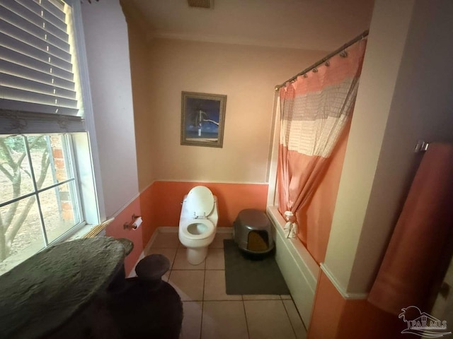 bathroom with toilet, tile patterned flooring, baseboards, and shower / tub combo with curtain