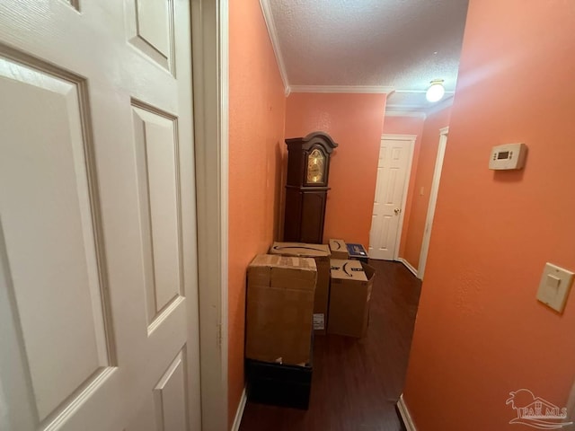 hall with crown molding, a textured ceiling, dark wood finished floors, and baseboards