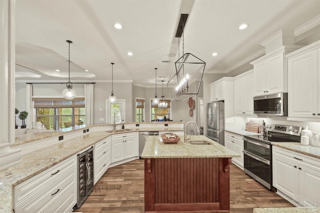 kitchen featuring kitchen peninsula, hanging light fixtures, sink, and stainless steel appliances