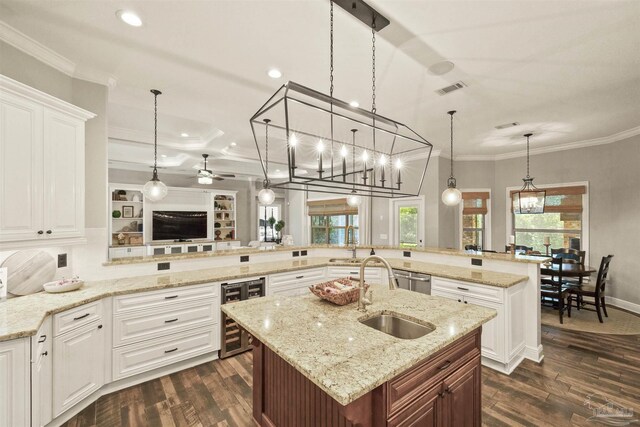 kitchen with beverage cooler, sink, dark hardwood / wood-style flooring, kitchen peninsula, and a center island with sink