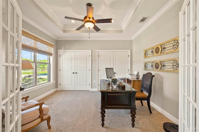 carpeted home office with crown molding, ceiling fan, and a raised ceiling