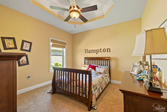 bedroom with light carpet, crown molding, ceiling fan, and a tray ceiling