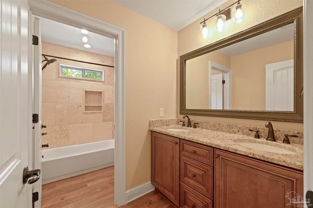 bathroom with vanity, wood-type flooring, and tiled shower / bath combo