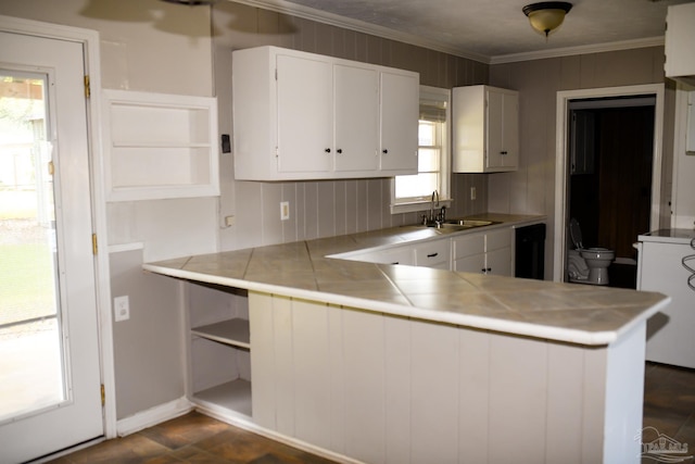 kitchen featuring kitchen peninsula, white cabinetry, a wealth of natural light, and sink