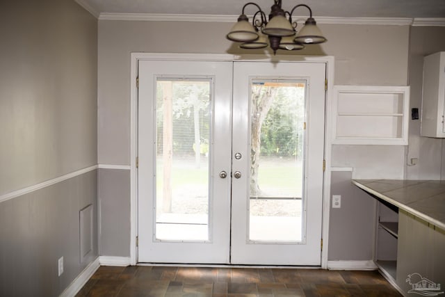 entryway featuring a wealth of natural light, french doors, crown molding, and an inviting chandelier