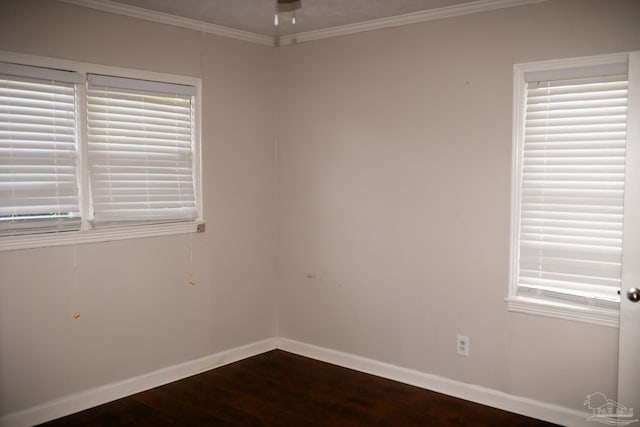 spare room featuring dark hardwood / wood-style flooring and ornamental molding