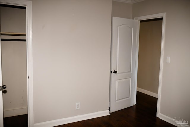 unfurnished bedroom with dark hardwood / wood-style flooring and a closet