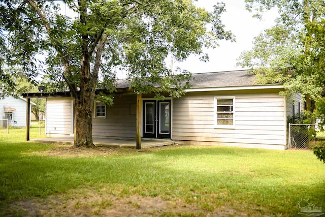 back of house with a yard and a patio