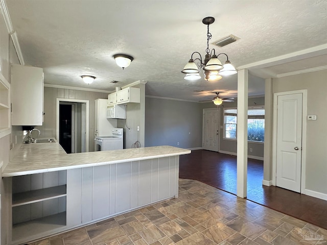 kitchen with a peninsula, light countertops, visible vents, and white cabinets