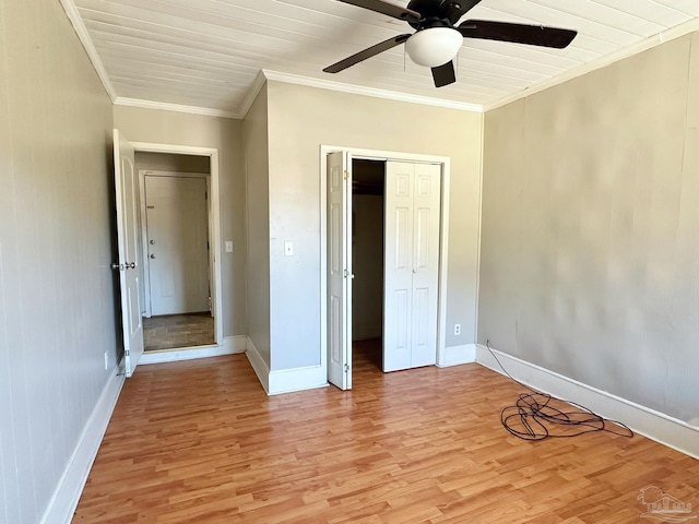 unfurnished bedroom featuring crown molding, a closet, ceiling fan, light wood-type flooring, and baseboards